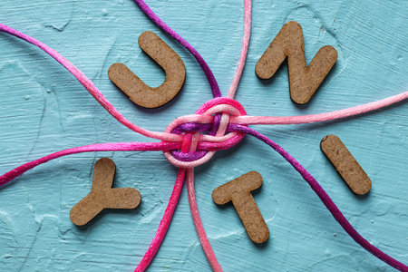 Braided cords tied together in the shape of an infinity sign on a blue background. communication concept.の写真素材
