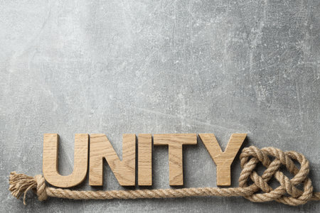 The word unity in wooden letters with a rope. Place for text