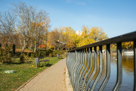 An autumn, sunny park in a big city, with a beautiful lake