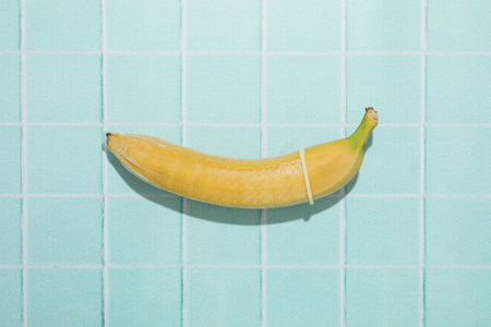 Condoms on bananas on a blue backgroundの写真素材