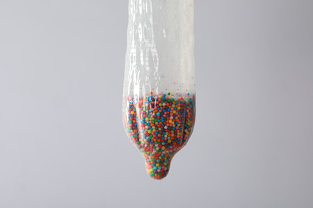 Condom with balls inside on a light background