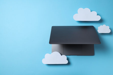 Laptop with paper clouds on a blue background, place for textの写真素材