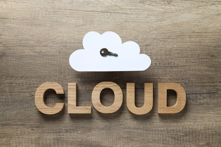 White, paper cloud with a key and the word "cloud" on a wooden backgroundの写真素材