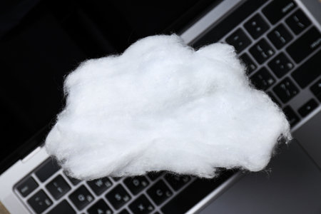 A white cloud made of cotton wool on a laptop keyboardの写真素材