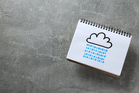 Notebook with a drawn cloud on a gray background, cloud computing concept, place for text