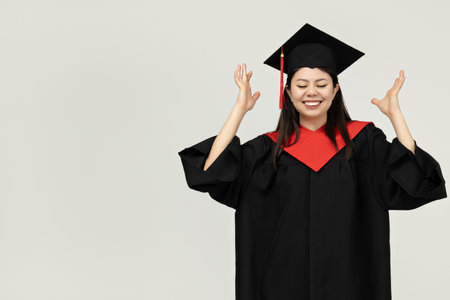 A girl of Asian appearance, a college graduate, on a gray backgroundの写真素材