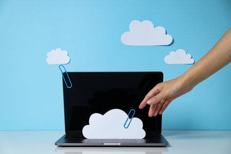 Laptop with paper clouds on a blue background