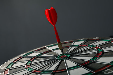 Darts hitting the target on a dark gray background.の写真素材