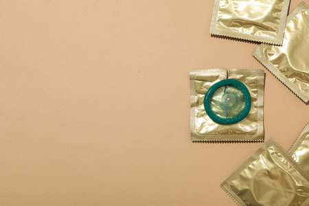 Condoms in a golden wrapper on a light background close-up, place for textの写真素材