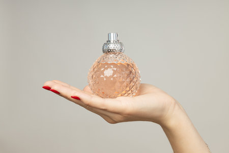 Perfume bottle in female hand on white backgroundのeditorial素材