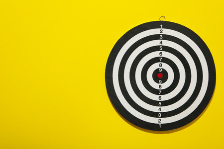 Darts hitting the target with wires on a yellow background.の写真素材