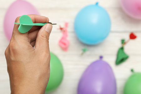 Throwing wires into balloons, on a light, wooden background.の写真素材
