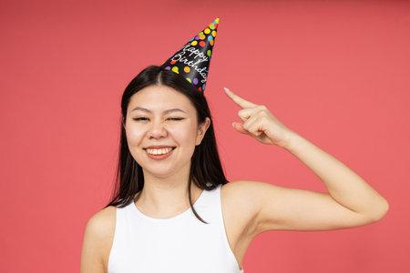 Asian girl with festive hat on her head, birthdayの写真素材
