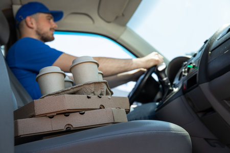 The courier delivers coffee and pizza by carの写真素材