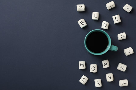 Cup and marshmallows with text Blue Monday on dark blue background, space for textの写真素材