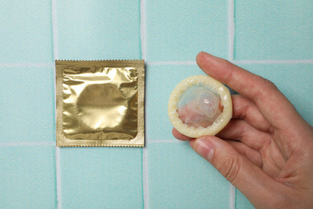 Sealed and opened condoms on a blue backgroundの写真素材