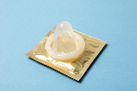 Close-up of an unpacked condom on a blue backgroundの写真素材