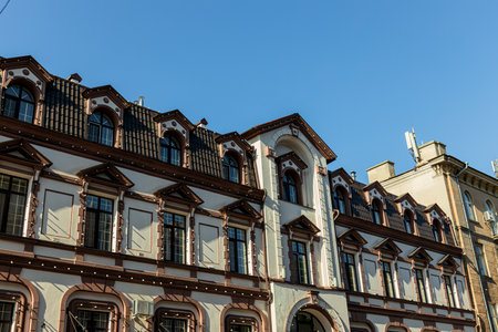 White building with brown roof in the city against the skyの写真素材