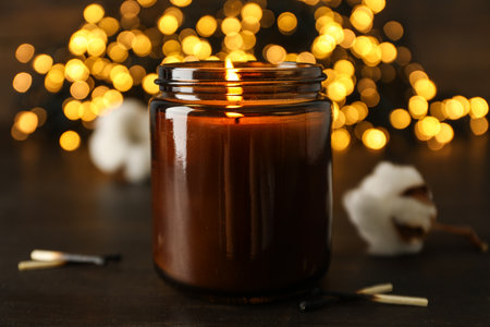 Candle on wooden table on dark background, close upの写真素材