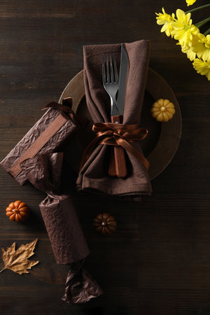Cutlery on plate, pumpkins and flowers on wooden background, top viewの写真素材