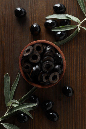 Olives in bowl on wooden background, top viewの写真素材