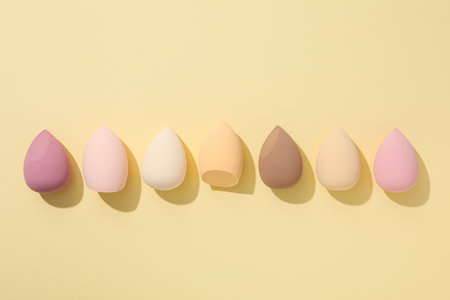 Cosmetic sponges on yellow background, top viewの写真素材