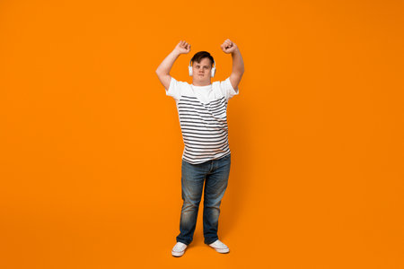 Smiling young man with down syndrome listening to music in headphonesの写真素材