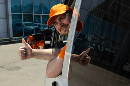 A smiling courier looks out of the car window and points a finger up