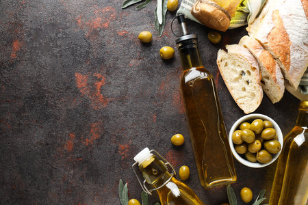 Bottles of olive oil, olives and slices of bread on gray background, space for textの写真素材