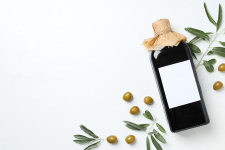Olive oil bottle and olives on white background, space for textの写真素材