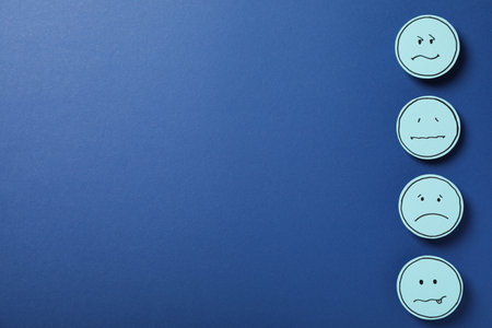 Sad emoji on dark blue background, space for text