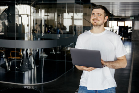 A cheerful young entrepreneur works in a modern workspaceの写真素材