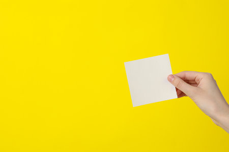 White blank paper in female hands, place for textの写真素材