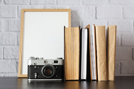 Vintage camera, photo frame and books on table on white backgroundの写真素材