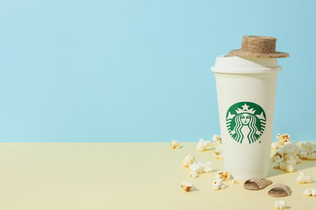 Ukraine, Kyiv, 24/08/2023: A cup of Starbucks coffee with a logo, on the background of a sea composition.のeditorial素材