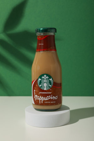 Ukraine, Kyiv, 08/24/2023: Starbucks frappuccino bottle with logo, on a green background.のeditorial素材