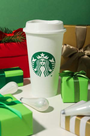 Ukraine, Kyiv, 08/24/2023: Starbucks coffee cup with logo, with gifts.のeditorial素材