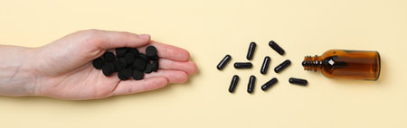 Tablets of activated carbon and a glass bottle on a light background