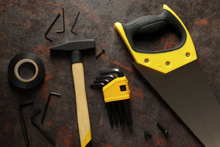 Construction tools on dark background, top view