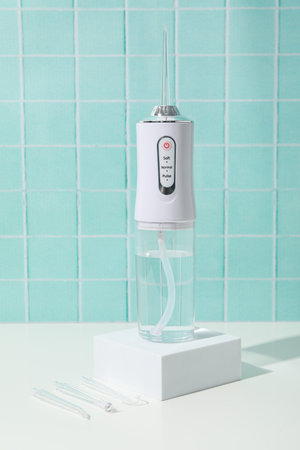 Irrigator on white table on green background