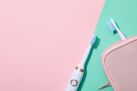 Electric toothbrushes and case on pink background, space for textの写真素材