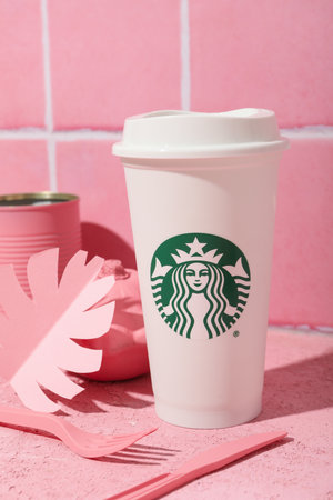 Ukraine, Kyiv, 24/08/2023: A cup of Starbucks coffee with the logo, on a pink background.のeditorial素材