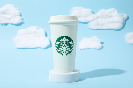 Ukraine, Kyiv, 24/08/2023: A cup of Starbucks coffee with the logo, on the background of the sky.のeditorial素材