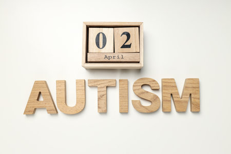 The word autism in wooden letters on a light background.World autism awareness day concept