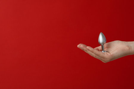 Metal anal plug on a red background.の写真素材