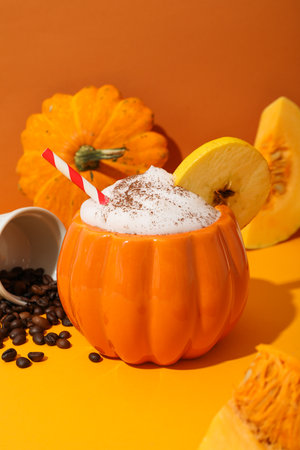 Coffee and pieces of pumpkin on orange backgroundの写真素材