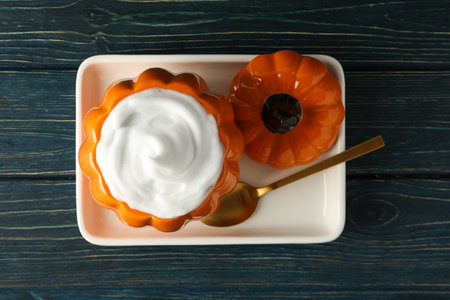 Coffee in glass pumpkin and golden spoon on wooden backgroundの写真素材