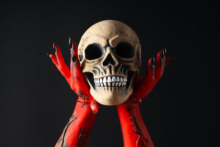 Creepy, red hands of the monster hold the skullの写真素材
