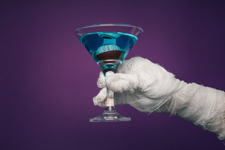 Hands wrapped in a bandage hold a cocktailの写真素材