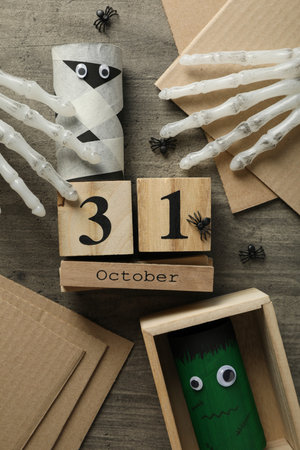 Date, halloween paper characters and decorative hand bones on wooden background, top viewの写真素材
